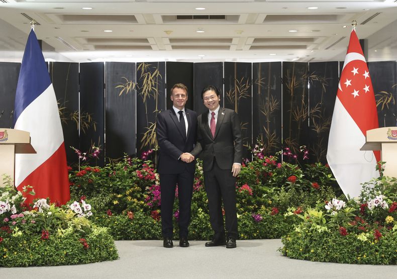 En esta imagen, distribuida por el Ministerio de Desarrollo Digital e Información de Singapur, el presidente de Francia, Emmanuel Macron (izquierda), estrecha la mano del primer ministro de Singapur, Lawrence Wong, durante una conferencia de prensa conjunta tras la firma de varios acuerdos bilaterales, en Singapur, el 30 de mayo de 2025. (MMinisterio de Desarrollo Digital e Información de Singapur vía AP)