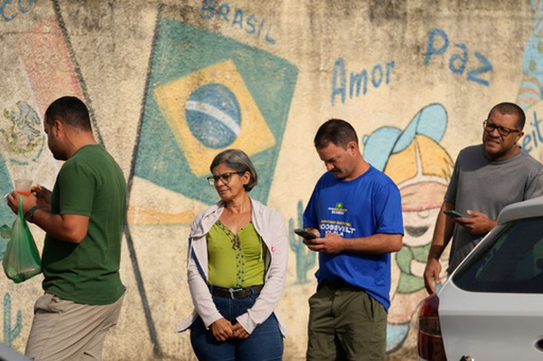 Electores hacen fila en un centro de votación durante las elecciones generales en Brasilia, el domingo 4 de octubre de 2026. (Foto AP/Eraldo Peres)