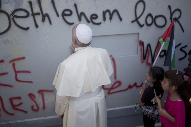 ARCHIVO - El papa Francisco ora junto a un muro erigido por Israel en su camino a una misa en la Plaza del Pesebre junto a la Iglesia de la Natividad, donde según la tradición nació Jesucristo, el domingo 25 de mayo de 2014, en Belén, Cisjordania. (AP Foto/Ariel Schalit, archivo)