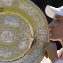 Elena Rybakina besa el trofeo de campeona del torneo de Wimbledon, el sábado 9 de julio de 2022. (AP Foto/Kirsty Wigglesworth)
