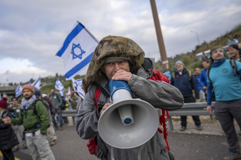 En esta imagen de archivo, reservistas del ejército israelí protestan contra el plan del gobierno del primer ministro, Benjamin Netanyahu, para revisar el sistema judicial, en la autovía entre Tel Aviv y Jerusalén, el 9 de febrero de 2023. (AP Foto/Ohad Zwigenberg, archivo)