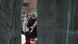 Varias personas dejan flores para honrar a Alexei Navalny en el Muro de Tristeza, un monumento para honrar a las víctimas de la represión política, en Moscú, Rusia, el sábado 17 de febrero de 2024. (AP Foto/Alexander Zemlianichenko)