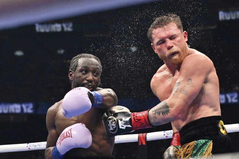 Terence Crawford propina un puñetazo al mexicano Saúl Canelo Álvarez en un combate por los títulos de los supermedianos, el sábado 13 de septiembre de 2025, en Las Vegas (AP Foto/David Becker)