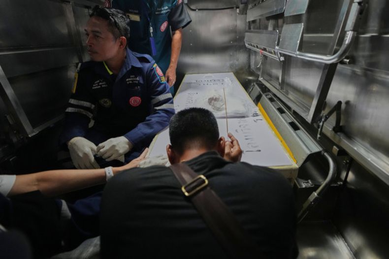 Un familiar de una víctima del incendio en un bar con música presenta sus respetos al cuerpo de la víctima en el hospital de la policía en Bangkok, Tailandia, el martes 14 de julio de 2026. (AP Foto/Sakchai Lalit)