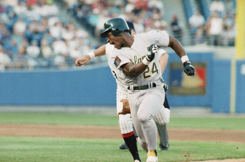 ARCHIVO - Rickey Henderson, de los Atléticos de Oakland, corre delante del venezolano Ozzie Guillén, de los Medias Blancas de Chicago, en un juego del 14 de junio de 1994 (AP Foto/Fred Jewell, archivo)