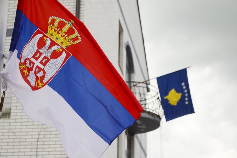 La bandera serbia (a la izquierda) ondea frente a una bandera de Kosovo en el ayuntamiento de Zubin Potok, en el norte de Kosovo, el 31 de mayo de 2023. (AP Foto/Marjan Vucetic, Archivo)
