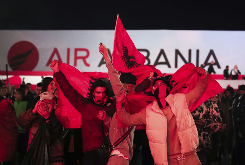 Fanáticos de Albania reaccionan en la Plaza Skandenberg mientras observan el partido en panatalla gigante, en el grupo E del clasificatorio a la Eurocopa 2024, entre Moldavia y Albania, en Tirana, Albania, el viernes 17 de noviembre de 2023. (AP Foto/Armando Babani)