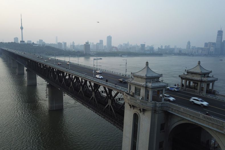 ARCHIVO - El sol se pone tras el puente en el río Yangtsé y la torre de televisión de la Montaña Tortuga en Wuhan, en la provincia central china de Hubei el 12 de abril de 2020. (AP Foto/Sam McNeil, Archivo)