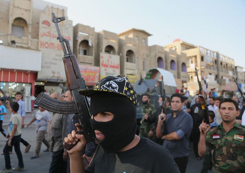 Combatienes tribales chi&iacute;tas alzan sus armas y corean lemas contra el grupo Estado Isl&aacute;mico en Irak y el Levante, vinculado con al Qaida, en Bagdad,el 16 de junio de 2014. (AP Photo/ Karim Kadim)