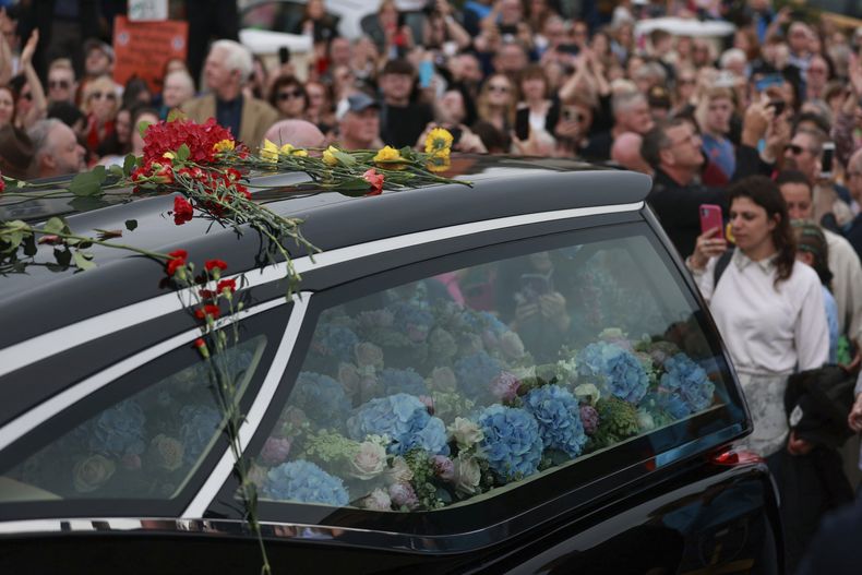 Fans de Sinéad OConnor rodean su cortejo fúnebre en Bray, la ciudad natal de la cantante en el condado de Wicklow, Irlanda, el martes 8 de agosto de 2023. La familia de OConnor invitó al público al paseo marítimo de Bray para despedirse de la artista. (Liam McBurney/ PA vía AP)