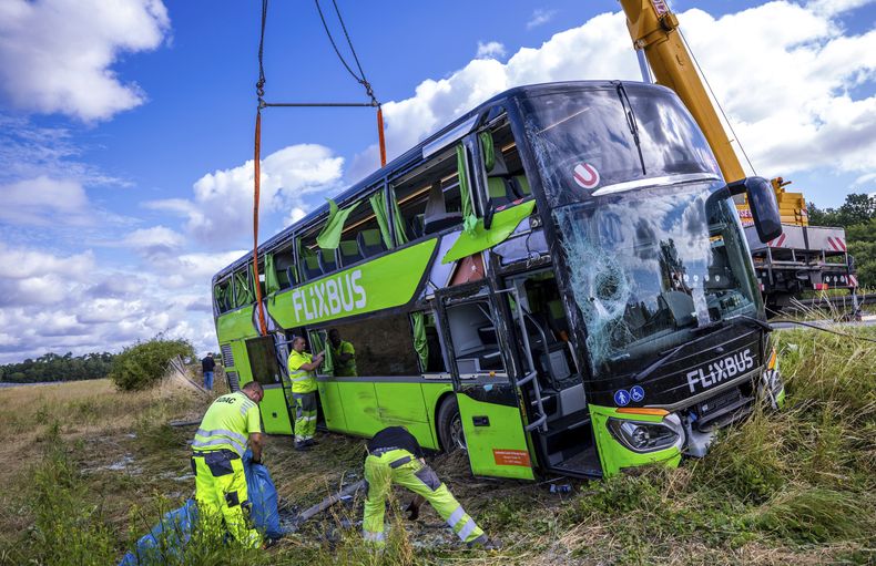 Los servicios de emergencia trabajan en el lugar donde un autobús volcó a la orilla de la autopista A19, cerca de Röbel, Alemania, el viernes 4 de julio de 2025. (Jens Büttner/dpa vía AP)