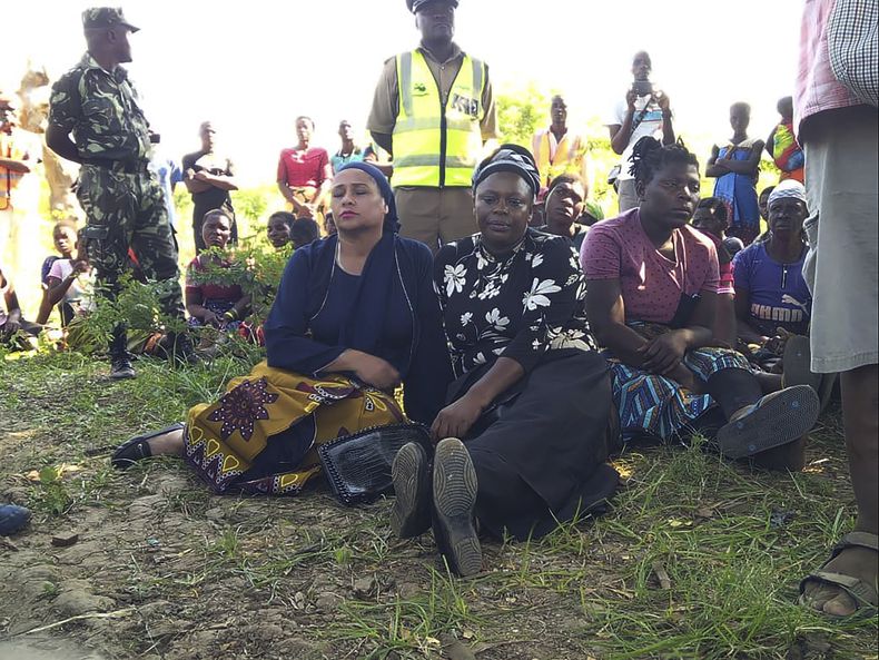 La ministra de Agua y Saneamiento de Malaui, Abida Mia (izquierda), espera junto a la miembro del Parlamento local, Gladys Ganda, por noticias sobre la operación de rescate en la orilla del río Shire, el martes 16 de mayo de 2023. (AP Foto/Austin Kachipeya)