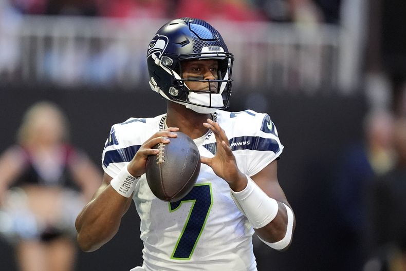 El mariscal de campo de los Seahawks de Seattle, Geno Smith (7), busca un receptor abierto durante la primera mitad de un partido de fútbol americano de la NFL contra los Falcons de Atlanta, el domingo 20 de octubre de 2024, en Atlanta. (AP Foto/ Brynn Anderson)