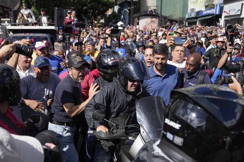 La líder opositora María Corina Machado con un casco y sentada en la parte trasera de una motocicleta mientras se la llevan después de dirigirse a la gente en una protesta contra el presidente Nicolás Maduro en Caracas, Venezuela, el jueves 9 de enero de 2025, el día antes de su toma de posesión para un tercer mandato. (AP Foto/Matías Delacroix)