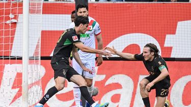 Gio Reyna de la mano a su compañero del Borussia Mönchengladbach tras anotar en el encuentro ante el Augsburg de la Bundesliga el sábado 9 de mayo del 2026. (Harry Langer/dpa via AP)