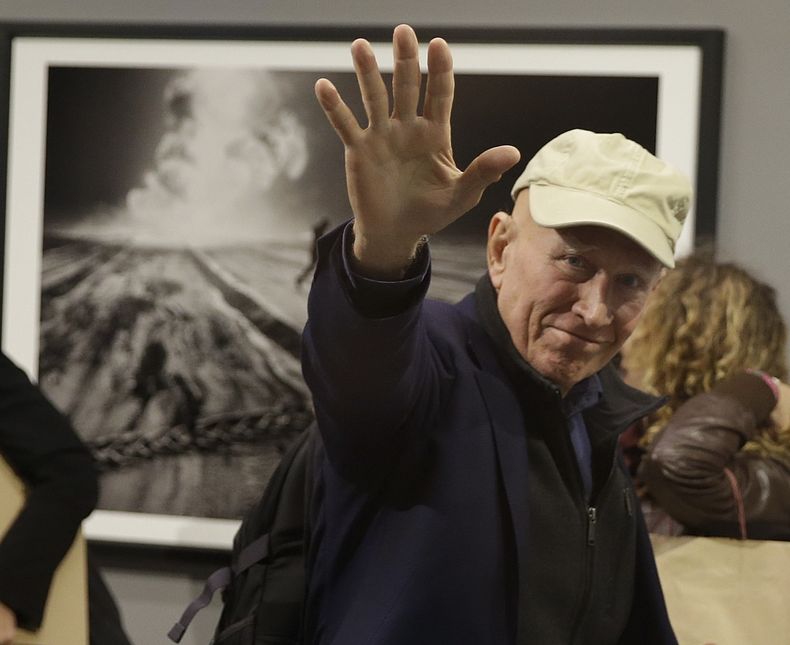ARCHIVO – El fotógrafo Sebastiao Salgado saluda a fotógrafos en la presentación de su muestra “Kuwait: Un desierto en llamas”, en la Galleria Meravigli, en Milán, Italia, el 20 de octubre de 2017. Salgado, conocido por sus proyectos a largo plazo e imágenes de la naturaleza y la humanidad, falleció a los 81 años, confirmó el Instituto Terra el viernes 23 de mayo de 2025. (AP Foto/Luca Bruno, Archivo)