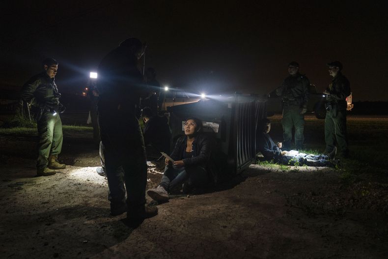 Migrantes que intentaban evadir a agentes de la Patrulla Fronteriza esperan a ser procesados el jueves 4 de mayo de 2023, en Granjeno, Texas. Un reciente incremento en la llegada de migrantes a la zona de Brownsville de la frontera entre Estados Unidos y México resalta los desafíos en materia migratoria, en un momento en que el gobierno estadounidense se alista a poner fin a una medida relacionada con la pandemia de coronavirus que permitía la expulsión rápida de muchos migrantes. (AP Foto/Veronica G. Cardenas, archivo)
