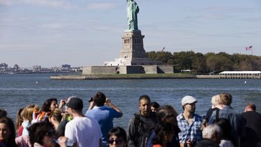 americateve | Turistas pasan cerca de la Estatua de la Libertad durante un recorrido en una embarcaci&oacute;n por diversos puntos importantes en el puerto de Nueva York, el s&aacute;bado 12 de octubre de 2013. La Estatua de la Libertad fue abierta nuevamente al doming