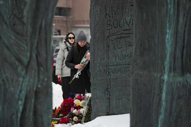 Varias personas dejan flores para honrar a Alexei Navalny en el Muro de Tristeza, un monumento para honrar a las víctimas de la represión política, en Moscú, Rusia, el sábado 17 de febrero de 2024. (AP Foto/Alexander Zemlianichenko)
