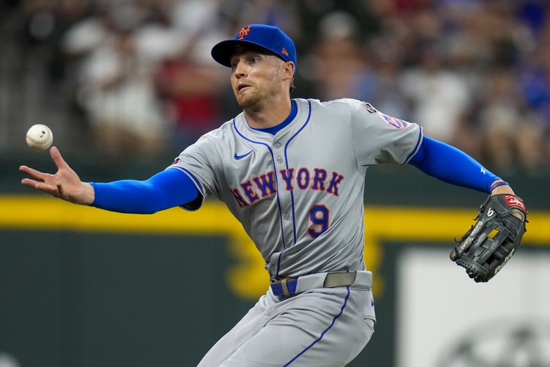 Brandon Nimmo, jardinero de los Mets de Nueva York, persigue un sencillo conectado por Jonah Heim, de los Rangers de Texas, durante la novena entrada del juego de béisbol del martes 18 de junio de 2024, en Arlington, Texas. Los Mets ganaron 7-6. (AP Foto/Julio Cortez)