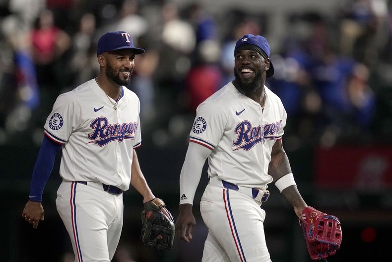 Marcus Semien (izquierda) y el cubano Adolis García festejan el triunfo de los Rangers de Texas, sobre los Azulejos de Toronto, en el encuentro del miércoles 18 de septiembre de 2024 (AP Foto/Tony Gutiérrez)