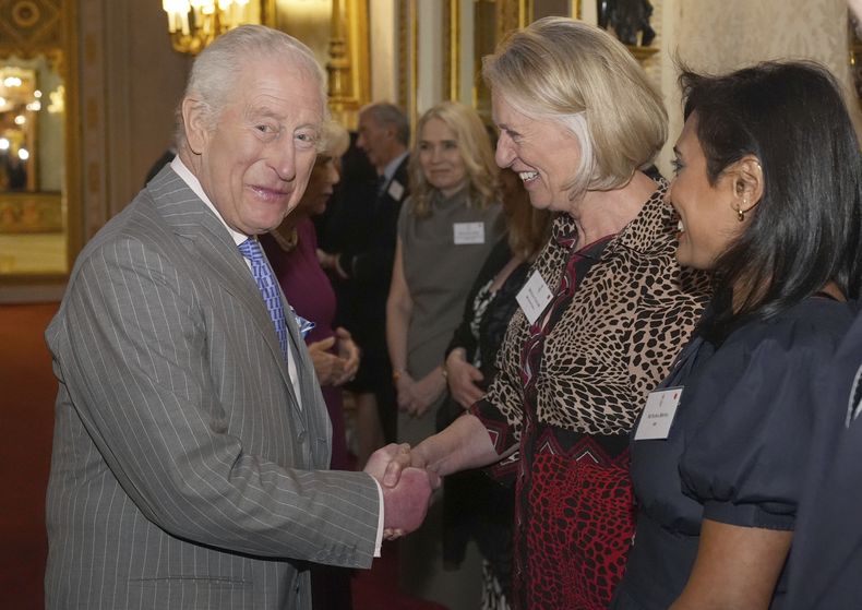 El rey Carlos III de Gran Bretaña saluda a una invitada durante una recepción en el Palacio de Buckingham, Londres, para invitados de una amplia gama de organizaciones de medios de todo el país, el miércoles 26 de marzo de 2025. (Aaron Chown, Pool via AP)