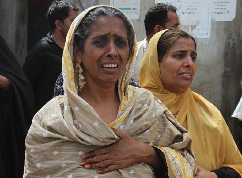 Residentes del barrio Lyari de Karachi, en Pakist&aacute;n, ante las secuelas de un ataque contra transe&uacute;ntes el mi&eacute;rcoles, 12 de marzo del 2014. (Foto AP/Fareed Khan)