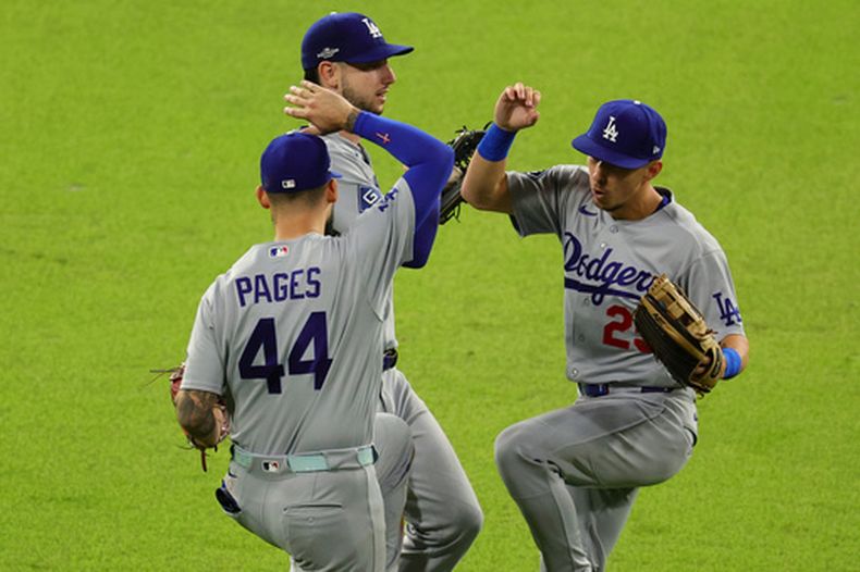 El jardinero central cubano de los Dodgers de Los Ángeles Andy Pages, Tommy Edman y el jardinero derecho Kyle Tucker celebran tras ganar el juego 4 de la serie divisional de la Liga Nacional ante los Bravos de Atlanta el miércoles 7 de octubre del 2026. (AP Foto/Colin Hubbard)