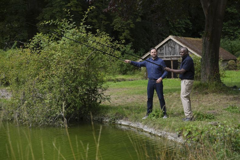 El vicepresidente estadounidense, JD Vance, y el secretario británico de Exteriores, David Lammy, pescan en un lago en los terrenos de Chevening House en Kent, Inglaterra, el viernes 8 de agosto de 2025. (AP Foto/Kin Cheung, piscina)