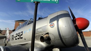 ARCHIVO - La señal de la calle Tuskegee Airmen Way se muestra brevemente frente a un avión North American T6 Texan de 1943 utilizado para entrenar pilotos durante la Segunda Guerra Mundial, en la Base de la Guardia Nacional Aérea de Selfridge, en Harrison Township, Michigan, 27 de febrero de 2018. (Todd McInturf/Detroit News via AP, archivo)