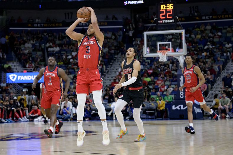 El escolta de los Pelicans de Nueva Orleans, CJ McCollum (3), lanza una canasta de 3 puntos después de robar un balón durante la primera mitad de un partido de baloncesto de la NBA contra los Trail Blazers de Portland, incluido el escolta Dalano Banton (5) en Nueva Orleans, el sábado 16 de marzo de 2024. (AP Foto/Matthew Hinton)