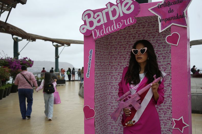 Una manifestante antigubernamental, disfrazada de Barbie Dictadora, sostiene un rifle de asalto de juguete, durante una protesta contra la presidenta Dina Boluarte en Lima, Perú, el sábado 22 de julio de 2023. (AP Foto/Martin Mejia)