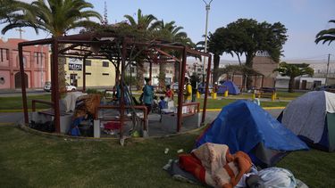 Migrantes venezolanos acampan en un parque en Tacna, Perú, el sábado 29 de abril de 2023. Una crisis migratoria en la frontera entre Chile y Perú se intensificó mientras cientos de migrantes permanecían varados al no poder cruzar a Perú. (Foto AP/Martín Mejía)