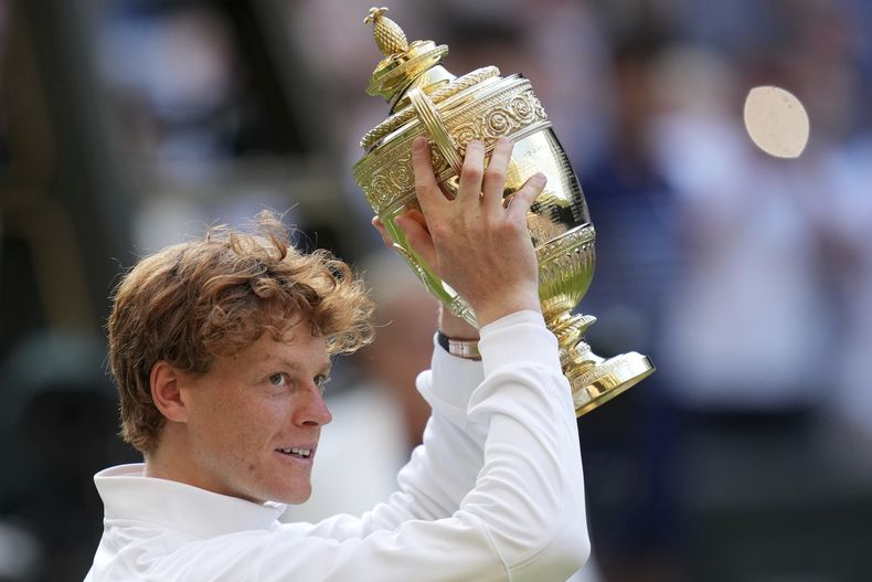 Jannik Sinner celebra con el trofeo tras vencer en la final de Wimbledon a Carlos Alcaraz, el domingo 13 de julio del 2025, en Londres. (AP Foto/Kin Cheung)