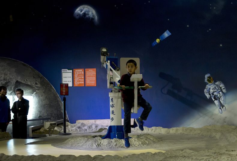 Un ni&ntilde;o juega con un aparato para caminatas espaciales en el Museo de Ciencia y Tecnolog&iacute;a de China en Beijing. El s&aacute;bado 14 de diciembre de 2013 China coloc&oacute; un veh&iacute;culo motorizado en la superficie de la Luna, la primer