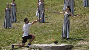 La actriz Mary Mina, quien realiza el papel de sacerdote le pasa la flama olímpica al primer relevo de la antoricha, el medallista olímpico griego Stefanos Douskos durante el último ensayo antes de la ceremonia del martes en Olimpia el lunes 15 de abril del 2024. (AP Foto/Thanassis Stavrakis)