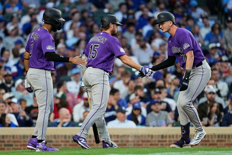 TJ Rumfield (derecha), de los Rockies de Colorado, celebra con Willi Castro (izquierda) y Hunter Goodman tras conectar un jonrón de dos carreras durante la cuarta entrada de un partido de béisbol contra los Cachorros de Chicago en Chicago, el martes 16 de junio de 2026. (Foto AP/Nam Y. Huh)