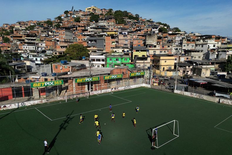 ARCHIVO - Anuncios de casas de apuestas adornan un campo de fútbol durante un programa de entrenamiento en la favela Complexo do Alemão, en Río de Janeiro, Brasil, el 1 de julio de 2023. (Foto AP/Bruna Prado, Archivo)