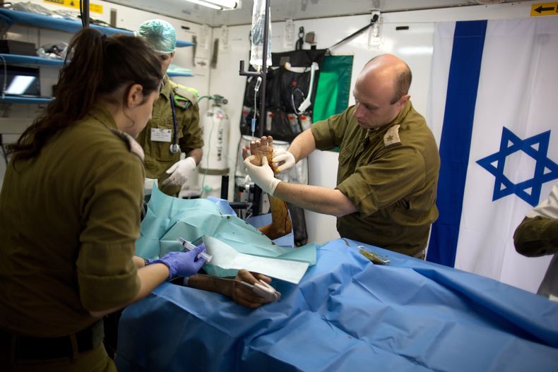 Miembros del ej&eacute;rcito israel&iacute; atienden a un sirio que result&oacute; herido en la guerra civil de Siria, en un hospital militar ubicado en los Altos del Gol&aacute;n cerca de la frontera siria, el martes 18 de febrero de 2014. (Foto AP/Menah