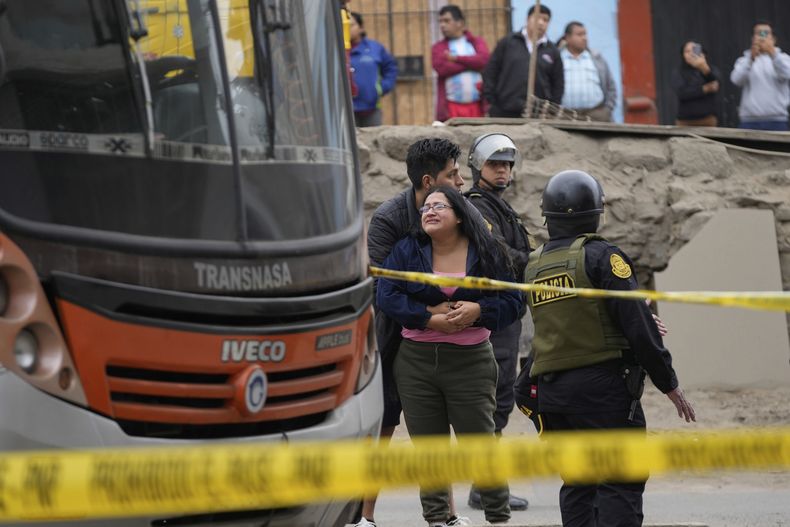 Familiares del conductor de autobús Arturo Ramón lloran junto al autobús donde fue asesinado, en el barrio de San Juan de Miraflores de Lima, Perú, el lunes 8 de septiembre de 2025. (AP Foto/Martín Mejía)
