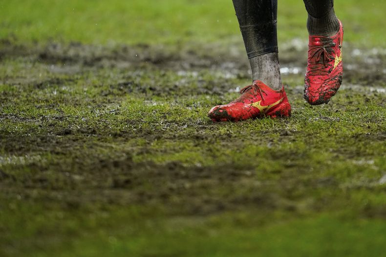 Un jugador camina sobre la cancha enfangada, antes del partido que terminó suspendiéndose, entre Saarbrücken y el Borussia Mönchengladbach, el miércoles 7 de febrero de 2024 (Uwe Anspach/dpa via AP)