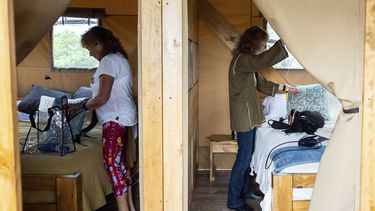Beverly Cookie Grant, izquierda, y Ellen Shelburne desempacan dentro de su tienda de campaña de lujo en el Centro para las Artes Bethel Woods, sede de la Feria de Arte y Música de Woodstock, el viernes 14 de junio de 2024 en Bethel, Nueva York. (Foto AP/Julia Nikhinson)