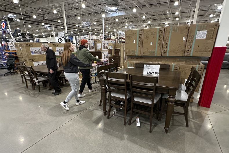 Varios consumidores pasan frente a un comedor en exhibición en un almacén de Costco el jueves23 de enero de 2025, en Sheridan, Colorado. (AP Foto/David Zalubowski)