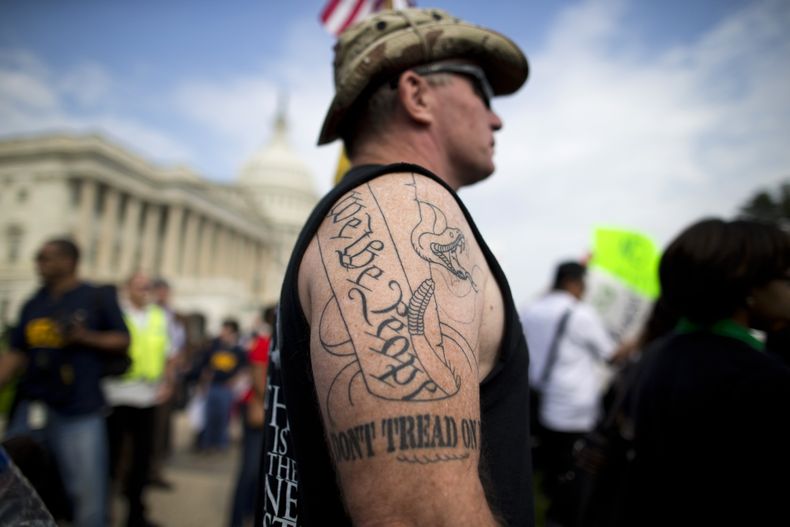 Greg Cummings, partidario del Tea Party y de Cincinnati, Ohio, observa una marcha de empleados federales cesados temporalmente contra los republicanos del Congreso en el Capitolio, el viernes 4 de octubre de 2013. Cummings asisti&oacute; a la macha para c