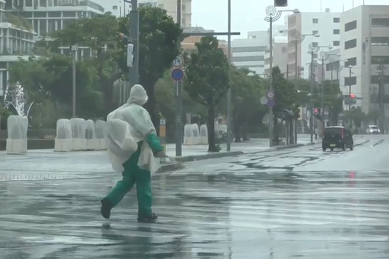 En esta imagen extraída de un video proporcionado por NTV-NNN, se ve a una persona caminando bajo la lluvia mientras el tifón Dolphin se acerca a Naha, Japón, el viernes 7 de agosto de 2026. (NTV-NNN vía AP)