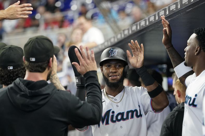 Bryan De La Cruz es felicitado por sus compañeros luego de su cuadrangular de dos carreras para los Miami Marlins en el juego ante los Filis de Filadelfia en Miami, el domingo 9 de julio de 2023. (AP Foto/Lynne Sladky)