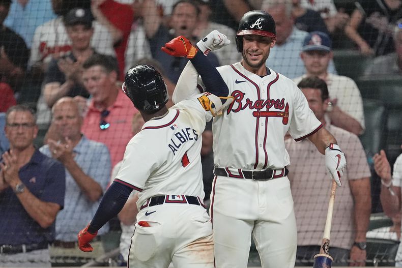 Ozzie Albies, de Atlanta, a la izquierda, celebra con Matt Olson después de adelantar a los Bravos con un jonrón solitario en la octava entrada contra los Tigres de Detroit, el lunes 17 de junio de 2024, en Atlanta. (AP Foto/John Bazemore)