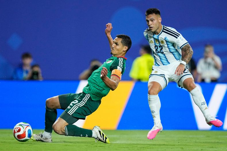 El delantero argentino Lautaro Martínez (22) se lanza ante la marca del argelino Aissa Mandi en el partido del Grupo J del Mundial en Kansas City, el martes 16 de junio de 2026. (AP Foto/Charlie Riedel)