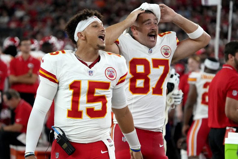 El quarterback Patrick Mahomes (15) y el tight end Travis Kelce, de los Chiefs de Kansas City, alientan a su equipo durante un partido de pretemporada ante los Cardinals de Arizona, el sábado 19 de agosto de 2023 (AP Foto/Rick Scuteri)