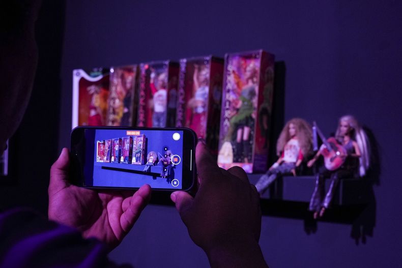 Un periodista toma un video de muñecas en una galería emergente con una exposición sobre la cantante colombiana Shakira en la colonia Roma Norte de la Ciudad de México, el jueves 20 de marzo de 2025. (Foto AP/Marco Ugarte)